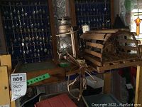 Photo showing the lobster trap lamp, the lantern light, and the wooden washboard together on a table.