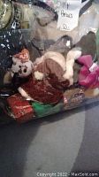 Plastic bag filled with various Ty Beanie Babies and a small teddy bear, showing plush animals with Ty heart tags.