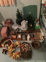 Overall view of holiday decorations including small trees, angel figurines, wreaths, and various boxes.