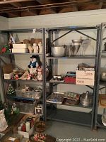 Two tall grey metal shelving units in a basement setting, shown stocked with items that are not for sale.