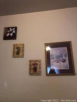 Wall art on bedroom wall, includes six pictures in different frames and sizes, floral and scenic themes.