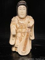 Front view of carved figure holding pipa