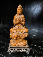 Front view of seated Buddha on stand