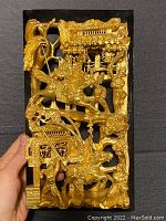 Front view of the antique Chinese gold gilt lacquered wood panel showing intricate carving of warriors on horseback, attendants, trees, and architectural elements.