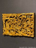 Front view of one gilt lacquer wood panel showing openwork carving