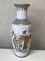 Front view shows elderly male and female figures with decorative border around neck