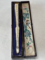 Closed lacquer box with carved fan handle inside and silk lining with painted birds and flowers