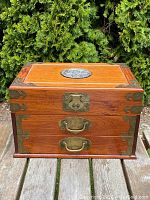 Full front view of hardwood box showing two drawers, central latch and top plaque
