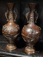Pair of bronze vases shown on black shelf