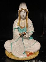 Front view of the seated Buddha with visible robe texture and painted details