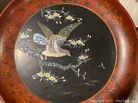 Angled close-up of bird and surrounding flowers with iridescent mother of pearl inlay capturing texture and color variations.