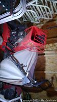 Full side view of Troy Bilt chipper/vac showing red metal chipper chute and white fabric bag attached to the rear with black engine visible