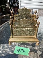 Front view of the bronze letter holder showing three engraved panels and finials.