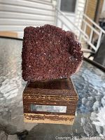Front view of the granite rock mounted on a wooden base with a metal plaque.
