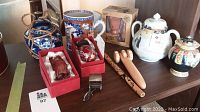Shelf overview showing porcelain mug, teapot, cloisonné pot and other items