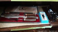 Bone handled carving knives in woven case labeled Haddon Hall with red lining, accompanied by a boxed pepper grinder.