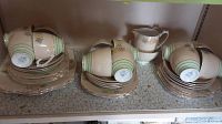 Photo showing three stacks of cups nested on saucers and larger plates underneath