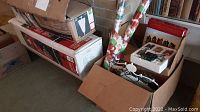 Boxes and wrapped items, including Christmas tree boxes and wrapping paper tubes; shows the stored condition and packaging of holiday decorations.