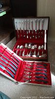 Overall view of two flatware boxes showing stainless steel cutlery and sterling silver flatware