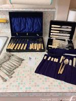 Overall display of three flatware sets and loose forks on countertop