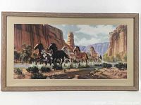 Full view of the framed painting showcasing the group of running horses in canyon scenery.