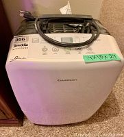 Front view of white Garrison dehumidifier showing control panel and power cord wound on top.