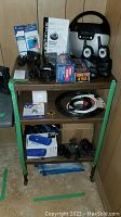 Entire lot on rolling cart showing portable stereo, walkie-talkies, cables, batteries, and manuals