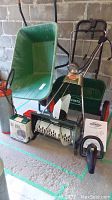 Sunbeam electric snow thrower with 18 inch clearing width, Scotts wheelbarrow behind, and box and manual for other items in lot