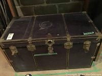 Front angle view of the vintage Atlas steamer trunk showing metal fittings and latch closures.