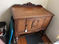 Front and side view of the walnut Jacobean style buffet showing carved door detail, turned legs, and top carved molding.