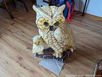 Front view of large beige ceramic owl figurine with a smaller owl on a ceramic branch base, showing detailed feathers and colored eyes.