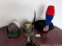 All three hats side by side on a wooden surface showing overall style and colors