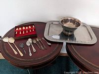 Overview of the mixed lot showing silver plated flatware, Revere style bowl on silver tray, and the Norwegian Sterling Silver butter cutting utensil.