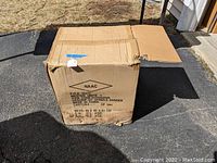 Closed cardboard box housing the spindle sander, labeled with product description and dimensions.