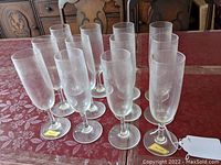 Full view of twelve champagne flutes arranged on a table.
