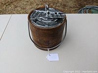 Front view of vintage Irvinware parquet-look ice bucket with chrome lid, handle, and tongs on lid