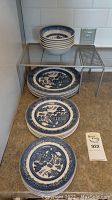 Stacks of plates and bowls displayed on countertop with metal shelving rack