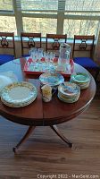 Overview of all items on the table including crystal glasses, pitcher, mug, and assorted plates with floral designs.