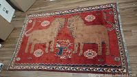 Full front view of rug laid flat on wood floor showing overall design and condition