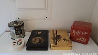 Full view showing four jewelry boxes and an antique hexagonal biscuit tin.