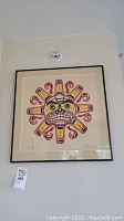 Full view of framed art print hung on wall with auction tag visible