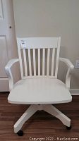Front view of the white wooden office chair showing slatted backrest, armrests, and flat seat.