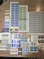 Full view of assorted vintage Canadian and US postage stamps, multiple blocks and sheets, primarily from mid-20th century.