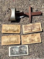 Photo showing the stereoscope viewer and all five stereoscopic cards laid out on the ground in sunlight.
