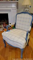 Front view of Lane Hickory Tavern upholstered arm chair showing beige and blue plaid fabric, removable seat cushion, and blue distressed wood frame with carved details.