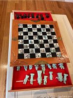 Full view of open folding chess set showing chessboard with Asian art squares and all chess pieces lined up in felt-lined case