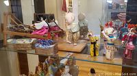 Asian dolls including a seated female doll weaving, standing baby doll, small Kabuki dolls, ceramic top boxes.