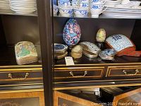 Overview of shelf with all ceramic and tin boxes and decorative eggs