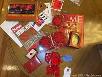 Top-down view of various memorabilia including magazines, pins, decorative red hanging ornaments, and booklets related to 1997 Hong Kong handover.