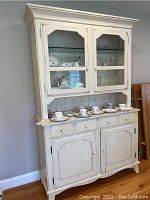 Front view of Nichols & Stone shabby chic painted wood china hutch with glass doors, drawers, and lower cabinet.